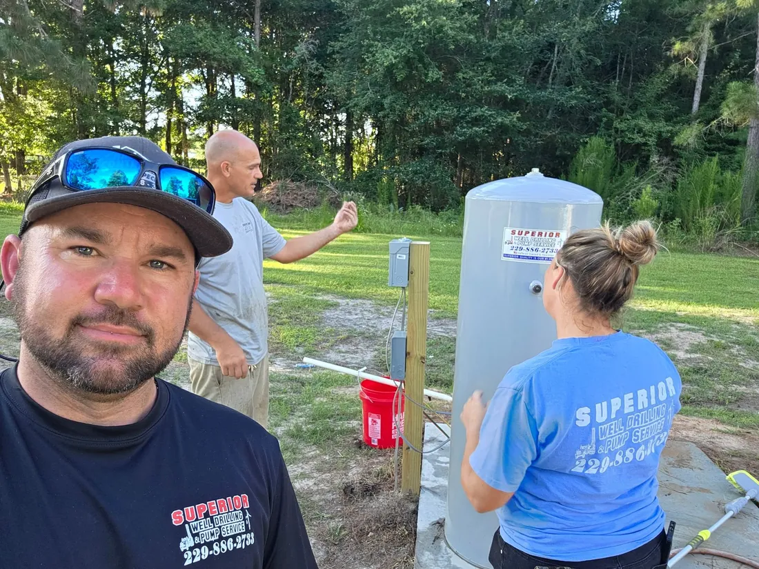 Superior crew members working on a new pressure tank installation at the edge of a field